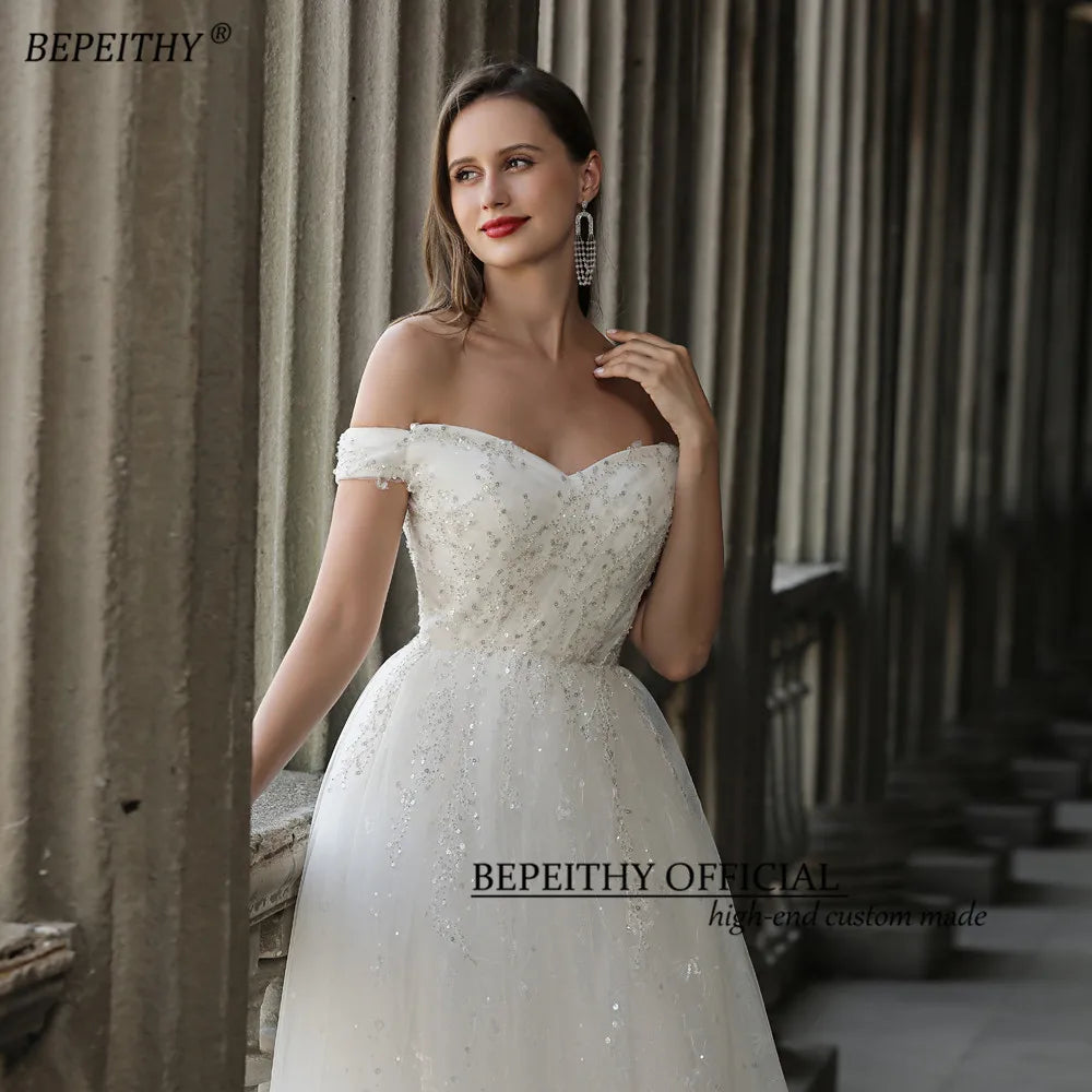 BEPEITHY Glittler Lace Vestidos de novia marfil para mujer 2023 Sin mangas Fuera del hombro Lujoso vestido de novia largo hasta el suelo